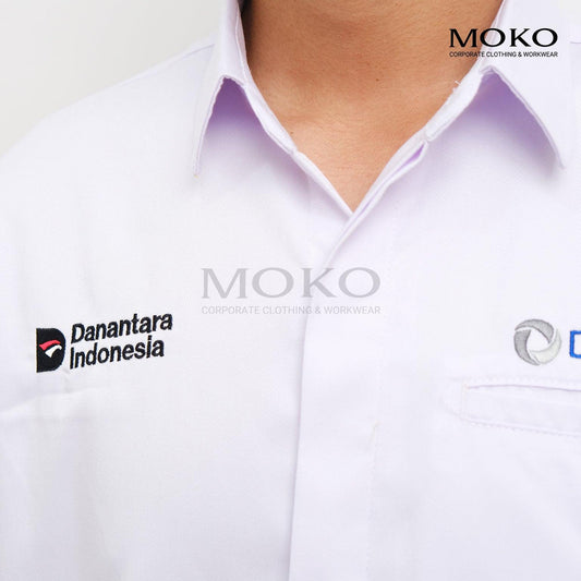 Close-up of a white professional corporate work shirt with Danantara Indonesia logo embroidery.